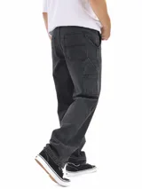 Jean estilo carpintero de corte oversized, color negro lavado, con múltiples bolsillos funcionales y presillas laterales.