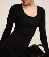 Vestido corto negro de punto acanalado con escote cuadrado y mangas largas. Detalle de textura diferenciada en la cintura.