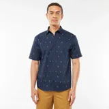 Camisa azul marino de corte recto y manga corta, con estampado de palmeras blancas.