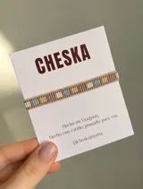 Pulsera hecha a mano con cuentas Miyuki en tonos beige, dorado, celeste, blanco y lila, con diseño geométrico y cierre regulable.