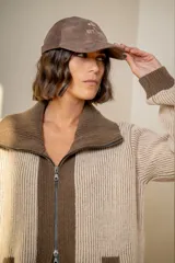 Campera de punto tipo cárdigan con cierre frontal de doble cursor, confeccionada en lana. Presenta un diseño bicolor con cuerpo en tono gris claro y detalles en azul marino en el cuello, la franja central, los bolsillos y los puños. Posee mangas largas con terminación ajustada y bolsillos frontales.