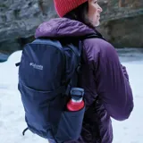 Mochila de senderismo Columbia Triple Canyon con capacidad de 24 litros, confeccionada en tejido resistente con tecnología Omni-Shield. Cuenta con panel trasero de malla transpirable, tirantes acolchados, compartimento compatible con sistema de hidratación, bolsillos laterales para botellas, enganches para bastones de trekking y funda impermeable integrada.
