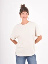Remera de algodón color beige, de corte holgado y diseño básico con cuello redondo y mangas cortas con dobladillo.