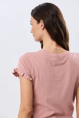 Remera de algodón color verde menta, con escote redondo y mangas corta con detalles de volados sutiles en los puños.