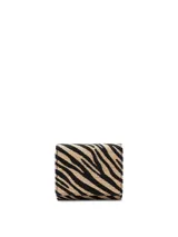 Billetera pequeña tipo tríptico con solapa y cierre de broche, confeccionada en paja tejida con estampado animal print de cebra en color negro y beige.