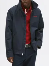 Campera Tommy Hilfiger modelo Regatta, color azul marino, con cierre de cremallera, cuello alto y dos bolsillos laterales. Logo de Tommy Hilfiger bordado en rojo en el pecho.