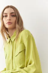 Camisa verde lima de manga larga con bolsillos diagonales con solapa en el frente.