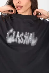 Remerón negro de corte oversize y mangas cortas, con estampa frontal difuminada estilo grafiti adornada con apliques de strass.