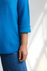Sweter de punto color azul, con escote a la base y mangas largas con puños doblados. Diseño holgado y versátil.