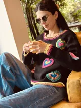 Sweater tejido artesanalmente en lana color negro, con apliques de corazones hechos a mano en crochet.