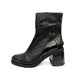 Bota corta de cuero vacuno color negro, con diseño de paneles combinados en cuero liso y cuero con textura de reptil en el talón y el taco. Presenta cierre en el talón, taco cuadrado forrado y suela de caucho.