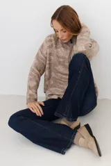 Buzo de tejido de punto con cierre frontal, cuello alto y diseño estampado en tonos beige y marrón.