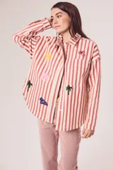 Sobrecamisa de algodón a rayas verticales rojas y blancas con bordados de un ojo egipcio, un sol, una palmera, un camello y una esfinge.