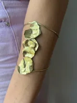 Brazalete plateado para el brazo, hecho a mano en alpaca, con diseño de formas orgánicas irregulares.