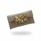 Bolso tipo sobre color dorado, confeccionado en yute de algodón con acabado texturizado y un llamativo aplique central metálico rectangular con piedras de resina en tonos tierra y gris. Incluye asa de cadena para llevar al hombro.