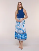 Vestido midi combinado de la marca Figueroa & Flower, con torso de modal azul sin mangas y cuello redondo, y falda evasé de rayón con estampado floral y paisajes en tonos blancos y azules, con cintura elastizada y lazo para anudar.
