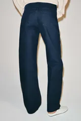 Jeans de tiro medio con diseño de perneras curvas y corte recto, confeccionados en denim con estampado paisley en tonos marrones y beige. Presentan diseño clásico de cinco bolsillos, trabillas para cinturón y cierre frontal con cremallera y botón metálico.