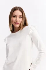 Remera de manga larga color marrón, con cuello redondo y detalle de volados en los hombros. Posee un corte ajustado al cuerpo.