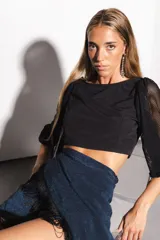 Falda tipo pareo corta, color azul metalizado con acabado brillante y flecos negros decorativos en el borde. Ajustable en la cintura.