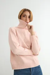 Buzo de punto gris con cuello polo y cierre frontal parcial, de manga larga y diseño holgado con puños y ruedo acanalados.