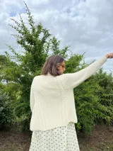 Cardigan tejido a mano color crudo, con solapa en el escote y punto delicado.