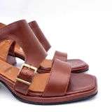 Sandalias de cuero color marrón con diseño de tiras anchas, hebillas metálicas doradas y taco ancho de madera de 4.5 cm.