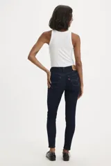 Jeans skinny de tiro medio color azul oscuro, ajustados en cadera y muslos, con cierre de bragueta.