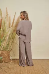 Conjunto de dos piezas color gris topo, con textura plisada. Incluye una blusa de manga larga y cuello redondo, y un pantalón de corte recto.