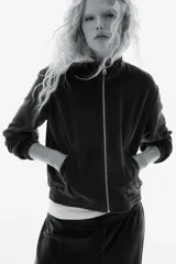 Campera corta de velour azul marino, con cuello alto, cierre frontal, bolsillos laterales y elástico fruncido en puños y bajo.