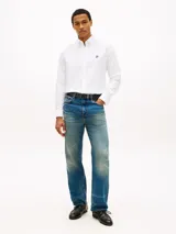 Camisa blanca de manga larga en tejido Oxford, de corte regular, con cuello abotonado y cierre frontal de botones. Cuenta con un pequeño logo bordado en el pecho.