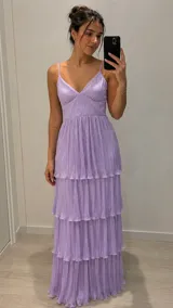 Vestido largo lila de tirantes finos, con escote en V y diseño escalonado de volados plisados con acabado brillante.
