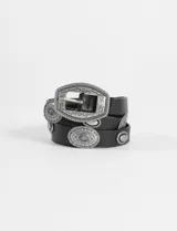 Cinturón de cuero sintético negro con hebilla ovalada y apliques metálicos circulares grabados con estilo western.