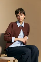 Cardigan de tejido de punto color rojo, con cuello redondo, cierre frontal de botones al tono y puños acanalados.