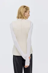 Top sin mangas de color beige confeccionado en punto roma, de corte entallado con costuras moldeadoras delanteras y traseras, cierre oculto en la espalda y detalle de peplum en la parte inferior.