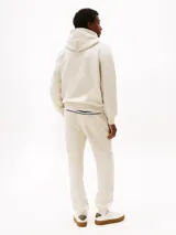 Buzo con capucha color gris claro, de corte regular, con cordón ajustable, bolsillo tipo canguro, puños y bajo de punto canalé. Logo de Tommy Hilfiger bordado en el pecho.