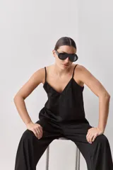 Top negro de breteles finos con escote en V y diseño minimalista, confeccionado en tela fluida y suave.