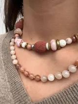 Collar corto de cuentas de piedra luna facetadas en tonos grises, blancos y durazno, con cierre de mosquetón dorado.