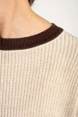 Sweater oversize de tejido de punto con diseño de rayas horizontales anchas en color beige y azul marino, cuello redondo marrón y puños y dobladillo en marrón con líneas beige y blancas.