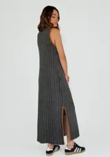 Vestido midi de punto con diseño a rayas verticales en tonos mostaza y blanco, con cuello redondo y sisas contrastadas en color bordó. Presenta aberturas laterales en el ruedo con detalles en color bordó.