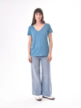 Remera de manga corta color azul claro, con cuello en V y corte holgado.