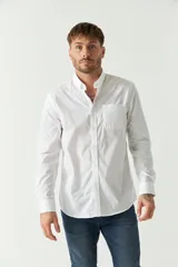 Camisa celeste de manga larga con logo bordado y bolsillo en el pecho.