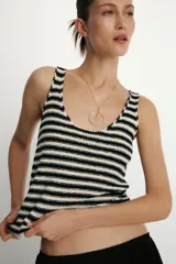 Top de punto sin mangas, color blanco y negro, con escote redondo y diseño a rayas horizontales.