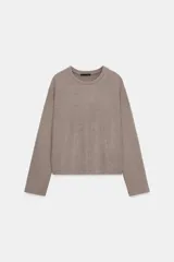 Top de tejido soft con cuello redondo, manga larga y bajo recto.