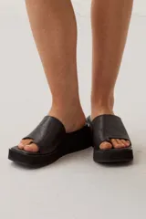 Sandalias plataforma Barina de color negro, con diseño tipo slide, suela chunky y textura sutil.