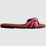 Sandalias tipo chinela Havaianas modelo You St Tropez, con base de goma color marrón y tira superior de tela con diseño de lazo estampado a rayas multicolor.