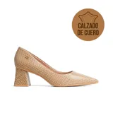Zapato de vestir Usaflex modelo Reva, color beige con textura de reptil, punta fina y taco cuadrado geométrico. Incluye detalle de logo metálico en el lateral.