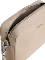 Cartera tipo bandolera o 'camera bag' de Calvin Klein, color beige claro, con exterior de piel sintética suave. Posee una correa ancha de jacquard con el logo repetido de la marca.