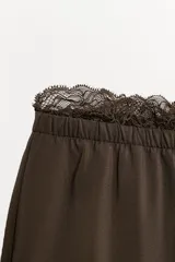 Shorts fluidos de tiro medio con cintura elástica y detalle de encaje a tono en el ruedo.