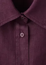 Camisa de lino color bordó con cuello camisero, manga larga con puños abotonados, bolsillo aplicado en el pecho y cierre frontal de botones.