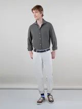 Camisa gris de punto liso para hombre, confeccionada en 100% algodón. Corte regular fit, cuello italiano, manga larga con puño simple y logo bordado en rojo en el pecho.